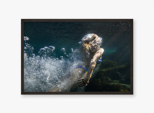 Person underwater with bubbles in a framed photograph