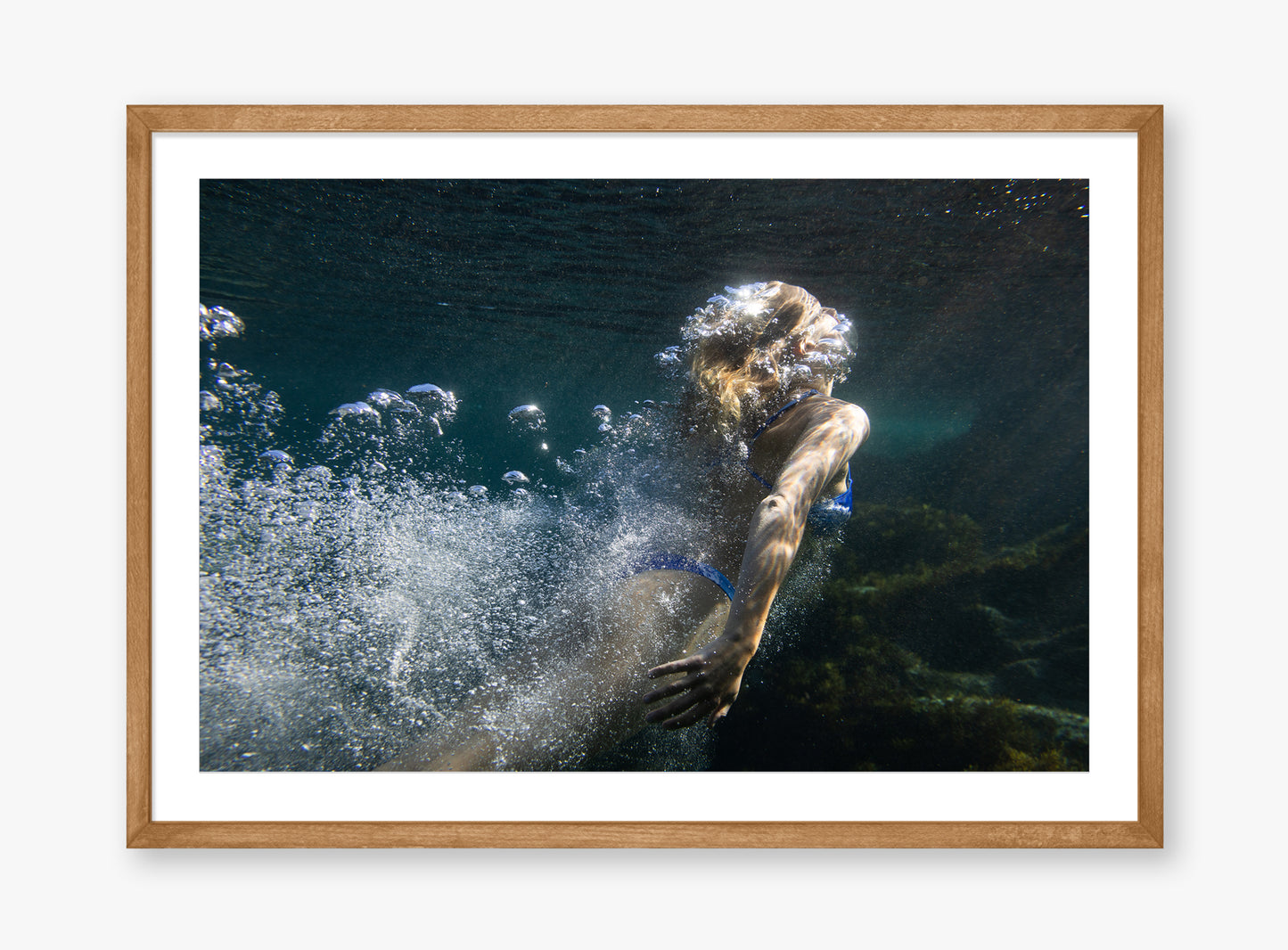 Framed artwork of a person diving underwater with bubbles, set against a white background.